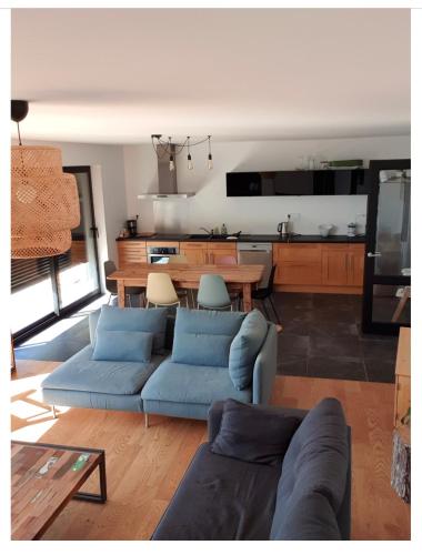 un salon avec un canapé bleu et une table dans l'établissement Les pieds dans l’eau, à Fouesnant