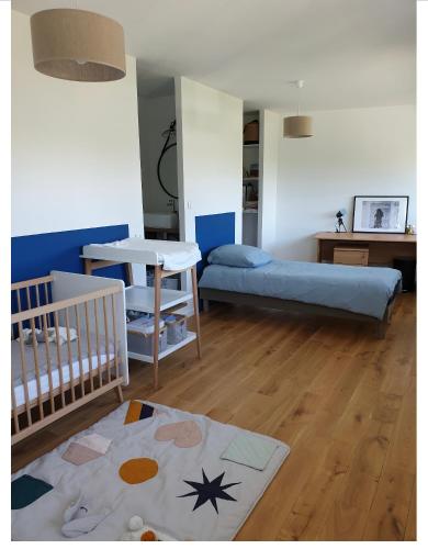 - une chambre avec un lit bébé et une table dans l'établissement Les pieds dans l’eau, à Fouesnant