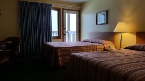 a hotel room with two beds and a window at Algoma Beach Motel in Algoma