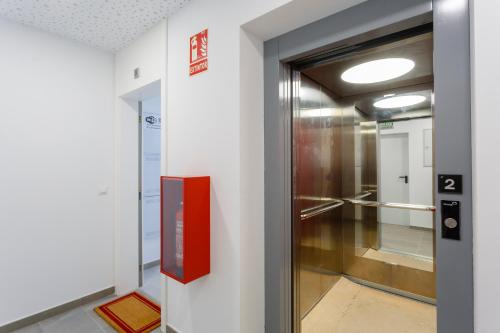 een elevatorexit in een gebouw met een rode deur bij POSEIDON Beach Apartment & parking by Cadiz4Rentals in Cádiz