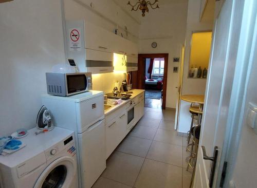 uma cozinha com uma máquina de lavar roupa e um micro-ondas em Classical Budapest apartment in the old Pest em Budapeste