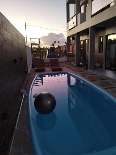 a swimming pool with a ball in the middle of a building at Bless in Maragogi