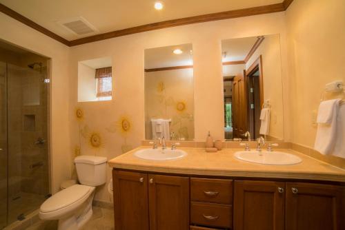 a bathroom with two sinks and a toilet and a shower at Los Suenos Resort Veranda 1B by Stay in CR in Herradura