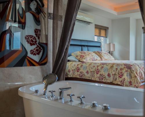 a bathroom with a bath tub and a bed at Seascape Villa in Montego Bay