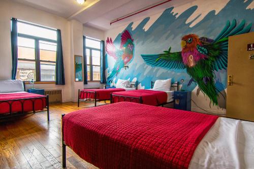 a bedroom with four beds and a mural of birds at NY Moore Hostel in Brooklyn