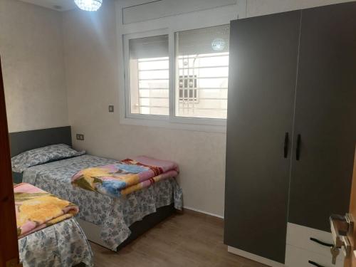 a small bedroom with two beds and a window at hay adrar 2 agadir Morocco in Agadir