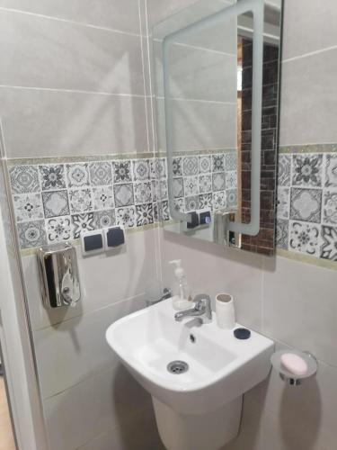 a white bathroom with a sink and a mirror at hay adrar 2 agadir Morocco in Agadir