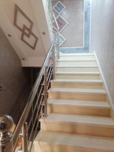 uma escadaria com piso de madeira e um corrimão de metal em hay adrar 2 agadir Morocco em Agadir