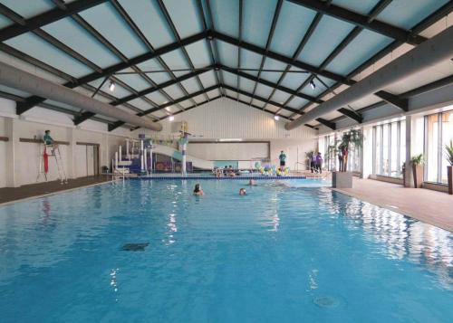 a large indoor swimming pool with people in it at Castle Brake Holiday Park in Woodbury