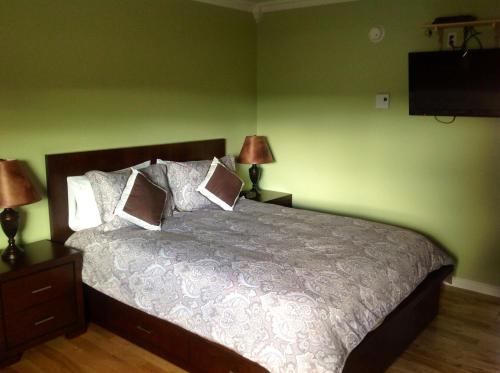 a bedroom with a bed with two lamps and a television at Parkside Inn in Haines Junction