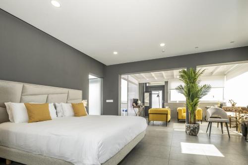 a bedroom with a large white bed and yellow chairs at Casa Saidera in Playa Blanca