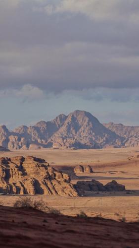 a view of a desert with a mountain in the background at Wadirum Zeid camp&Tours in Wadi Rum