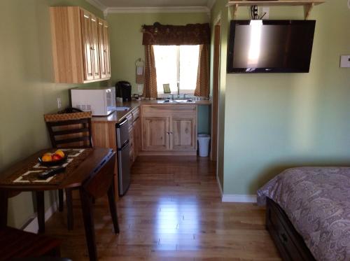 a kitchen with a bed and a table in a room at Parkside Inn in Haines Junction