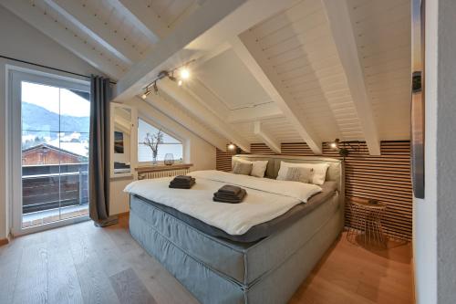 a bedroom with a large bed and a large window at Ferienwohnung #TIMEOUT in Pfronten