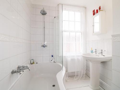 a white bathroom with a tub and a sink at 20 Crown Street in Newark-on-Trent