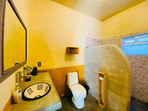 a bathroom with a white toilet and a sink at La Casa del Lago in Malinalco