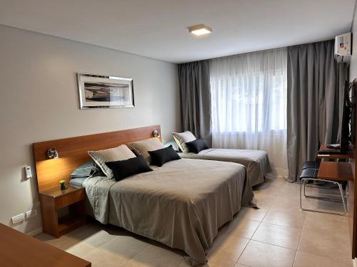 a hotel room with two beds and a window at Suite del sol 120 in Pinamar