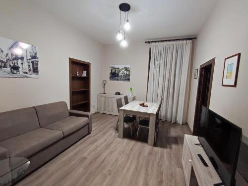 ein Wohnzimmer mit einem Sofa und einem Tisch in der Unterkunft Lo Stemma B&B Guest House in Melfi