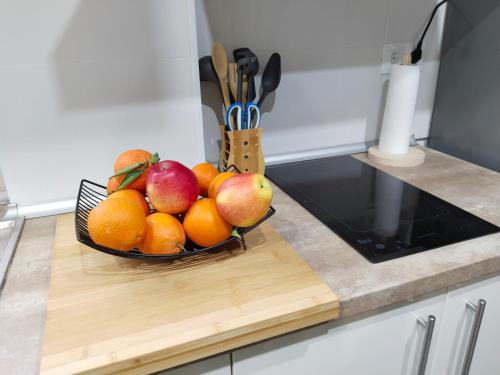 a bowl of fruit on a cutting board on a kitchen counter at Acogedor apartamento loft in Alhaurín de la Torre