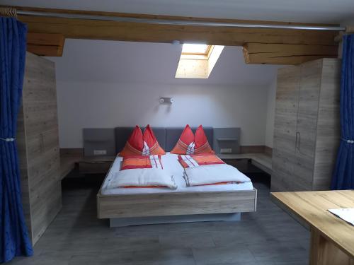 ein Schlafzimmer mit einem Bett mit roten Kissen darauf in der Unterkunft Nagelehof 2 in Ainet