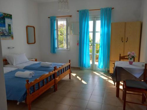 1 dormitorio con 2 camas y cortinas azules en Jenny Apartments, en Karlovasi