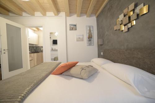 a bedroom with a bed with white sheets and orange pillows at b&b Due Perle in Chioggia