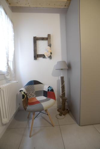 a chair sitting in a room with a lamp at b&b Due Perle in Chioggia