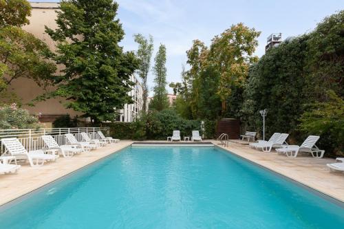 una piscina con tumbonas y una piscina en Appart Hotel Corte HR, en Corte