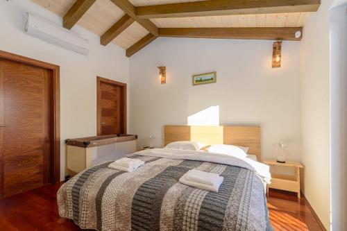 - une chambre avec un grand lit et 2 serviettes dans l'établissement Villa David - luxurious secluded villa with a heated pool, à Butkovići
