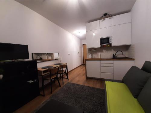 a living room with a couch and a kitchen at Apartament Zachód in Warsaw