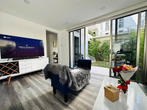 a living room with a large tv and a blue chair at Habitación privada in Guatemala