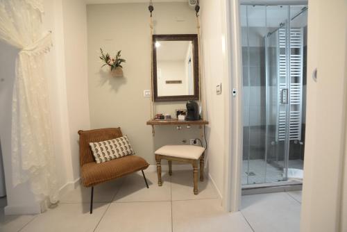 W łazience znajduje się krzesło, lustro i prysznic. w obiekcie b&b Due Perle w mieście Chioggia