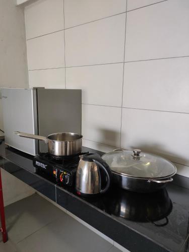 two pots and pans on a stove in a kitchen at Fraser Hill Silverpart Resort A3-1-1 Forest View With Lift in Bukit Fraser