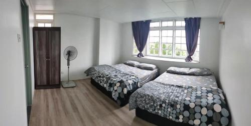 um quarto com 2 camas e uma janela em Fraser Hill Silverpart Resort A3-1-1 Forest View With Lift em Bukit Fraser