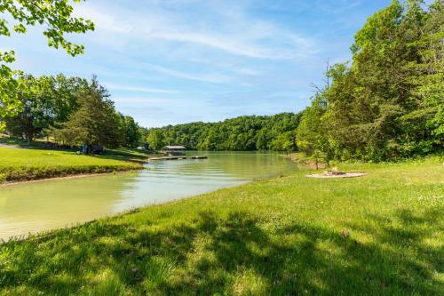 a river in a park with a green field and trees at Chapel Cove in Dandridge