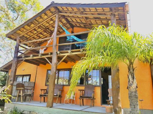 a house with a pergola on a patio at Rosatrip Surf Bungalows in Praia do Rosa