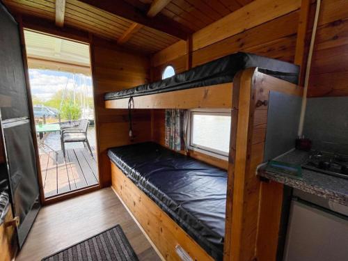 DargunにあるHausfloßvermietung auf der Peene am Kummerower See in Mecklenburg Vorpommernのキャビン内の二段ベッド1台が備わる小さな客室です。