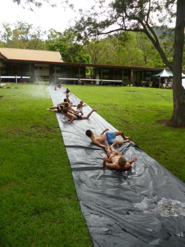 a group of people laying on a tarp in the water at Christmas Creek Café & Cabins in Lamington