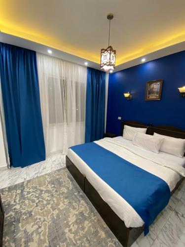 niebieska sypialnia z dużym łóżkiem i niebieską ścianą w obiekcie Sunterra w Szarm el-Szejk
