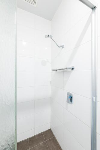 a shower with a glass door in a bathroom at Bunk Brisbane in Brisbane