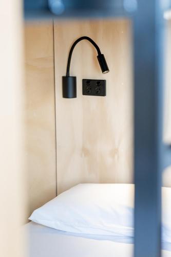 a lamp on a wall next to a bed at Bunk Brisbane in Brisbane