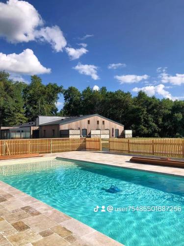 - une piscine en face d'une clôture en bois dans l'établissement Gîtes du Domaine de la Gauderie, à Notre-Dame-de-Sanilhac