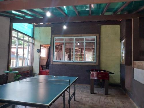a ping pong table in a room with a window at Pousada Beija flor in Extrema