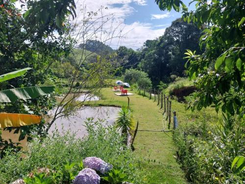 a river with a boat in the water and trees at Pousada Beija flor in Extrema