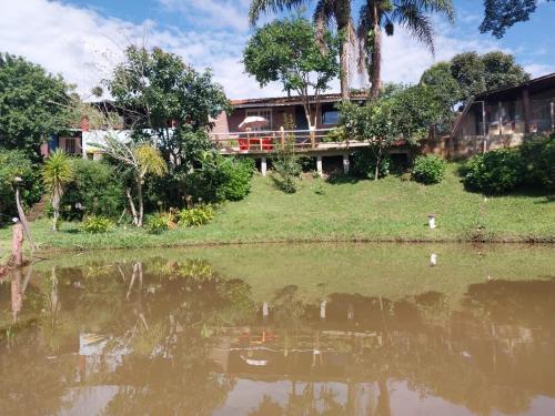 a house next to a body of water at Pousada Beija flor in Extrema