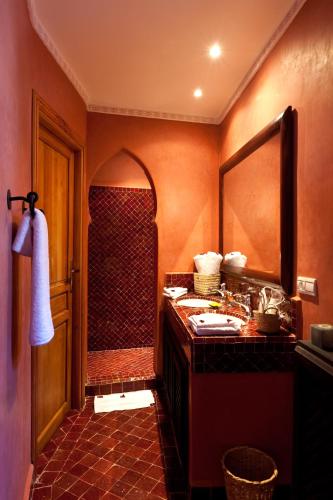 a bathroom with a shower with a sink and a mirror at Hotel & Spa Riad El Walaa in Marrakesh