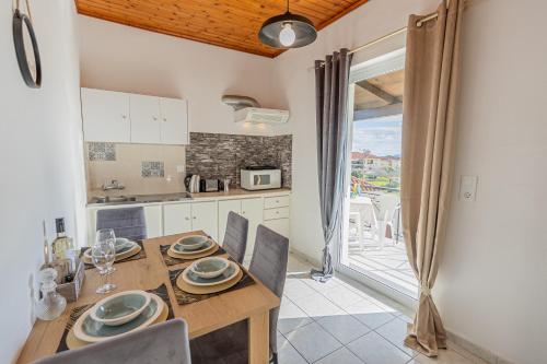 una cucina e una sala da pranzo con tavolo e sedie di Sarita's Apartments & Suite a Laganas