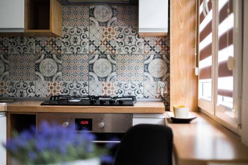 a kitchen with a stove and a clock on the wall at Apartament Paderewskiego 20A in Przemyśl