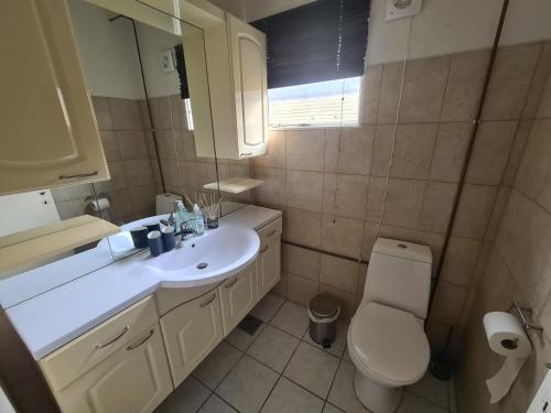 a bathroom with a white sink and a toilet at Cozy Room in the heart of Rødby! 5km from Femern & Puttgarden! in Rødby