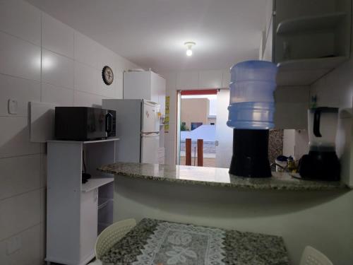 a kitchen with a counter with a bottle of water on it at Apartamento Térreo Villa das Águas in Estância